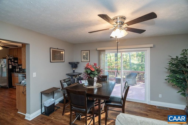 dining area featuring a textured ceiling, dark wood-type flooring, and ceiling fan