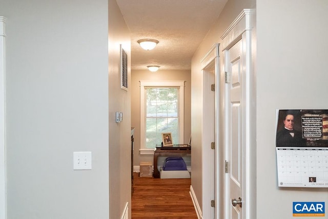 hallway featuring a textured ceiling and hardwood / wood-style flooring