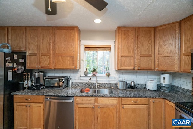 kitchen featuring stainless steel dishwasher, sink, a textured ceiling, and backsplash