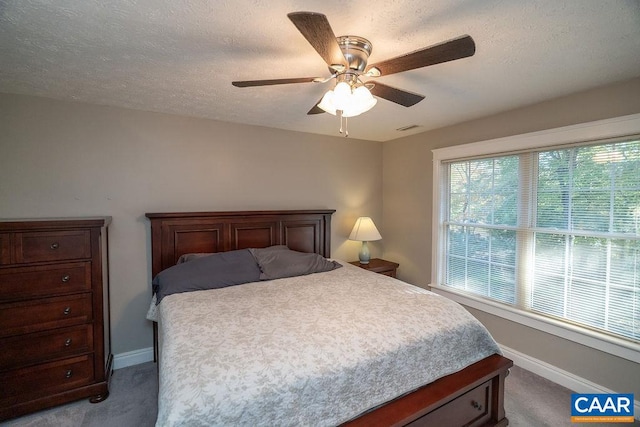 carpeted bedroom with a textured ceiling and ceiling fan