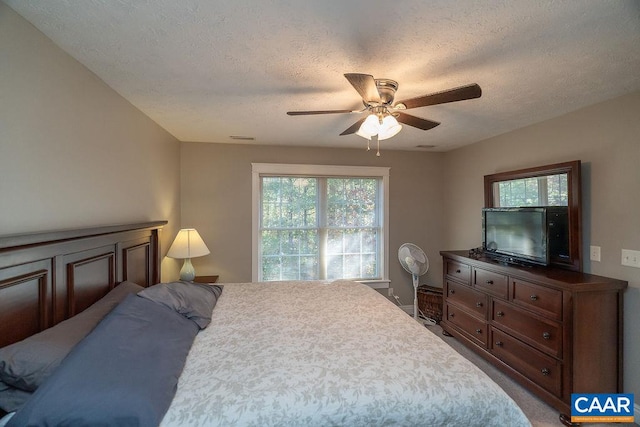 bedroom featuring a textured ceiling, carpet, and ceiling fan