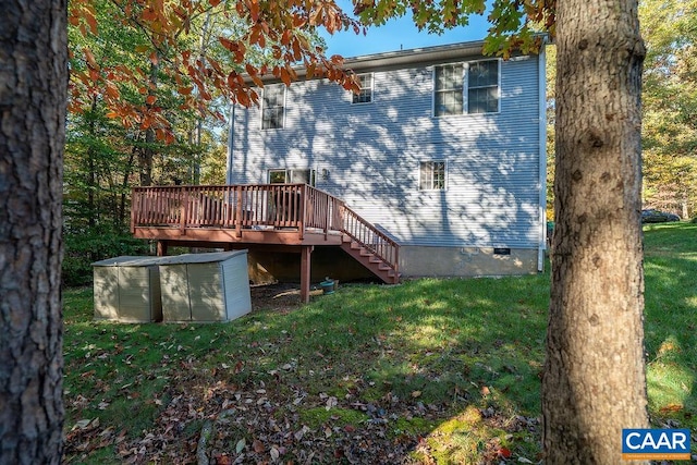 rear view of house featuring a wooden deck and a yard