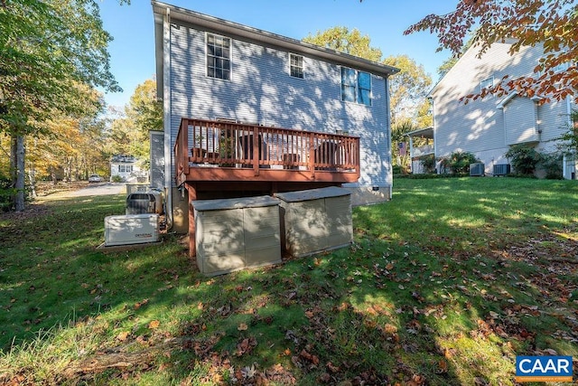 back of property with a wooden deck, a yard, and central AC unit