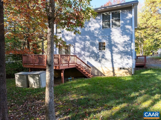 back of house with a deck and a yard