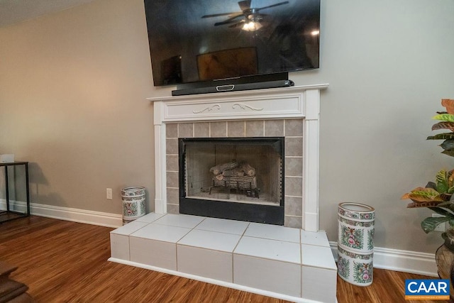 room details with hardwood / wood-style flooring, a tile fireplace, and ceiling fan