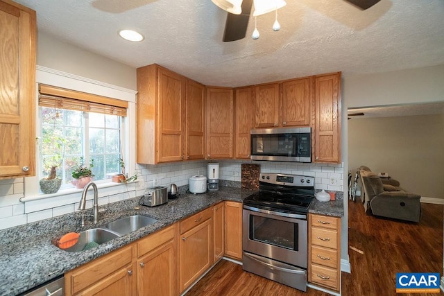 kitchen featuring sink, stainless steel appliances, decorative backsplash, and dark hardwood / wood-style flooring