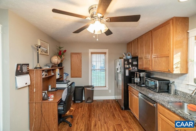 kitchen with hardwood / wood-style floors, tasteful backsplash, appliances with stainless steel finishes, a textured ceiling, and ceiling fan