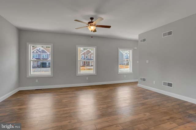 unfurnished room with dark wood-type flooring, ceiling fan, and a healthy amount of sunlight