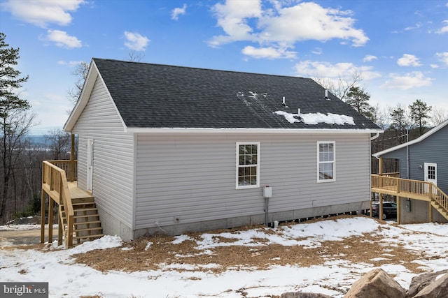 snow covered rear of property featuring a wooden deck