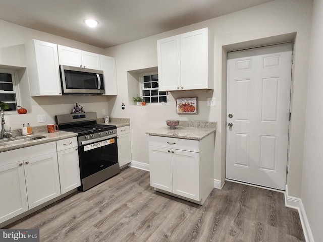 kitchen featuring white cabinetry, sink, hardwood / wood-style floors, and appliances with stainless steel finishes