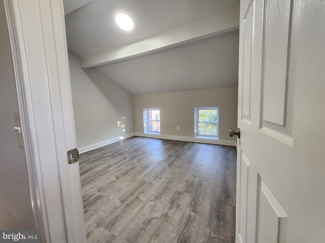 spare room featuring vaulted ceiling with beams and light wood-type flooring