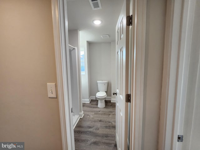 bathroom with hardwood / wood-style floors and toilet