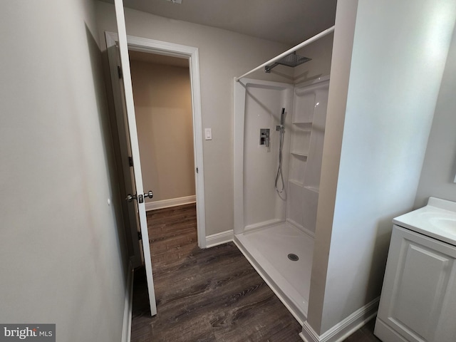 bathroom with a shower, vanity, and wood-type flooring