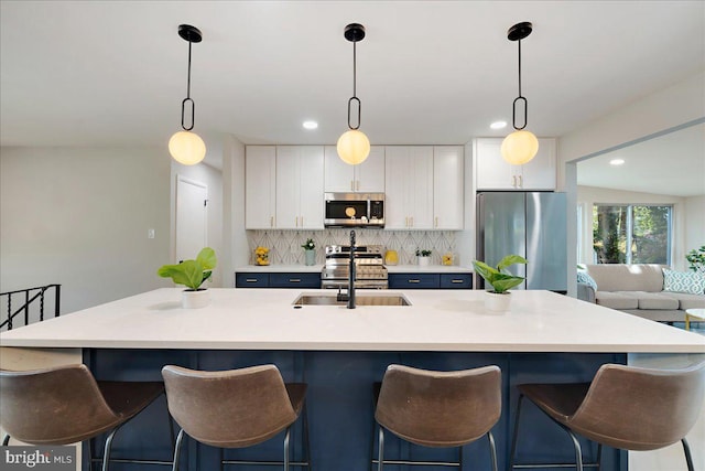 kitchen with pendant lighting, a kitchen island with sink, and stainless steel appliances