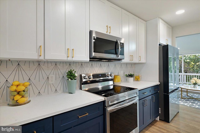 kitchen with light hardwood / wood-style floors, appliances with stainless steel finishes, white cabinets, and tasteful backsplash