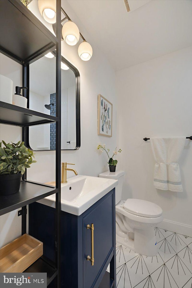 bathroom with toilet, vanity, and tile patterned flooring