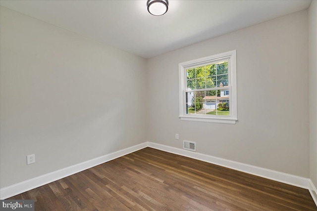 spare room with dark wood-type flooring