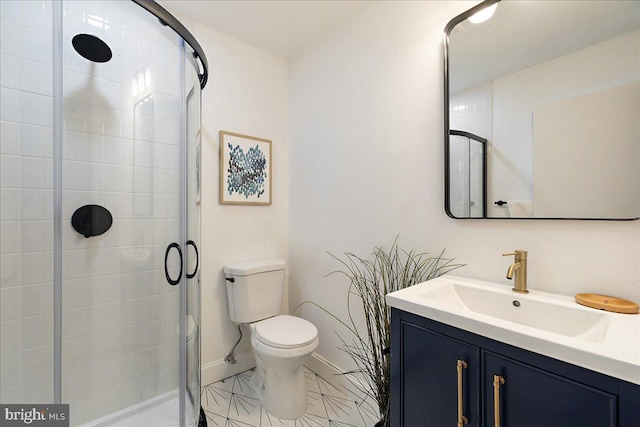 bathroom featuring vanity, tile patterned flooring, toilet, and walk in shower