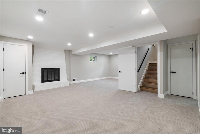 basement with light carpet and a fireplace