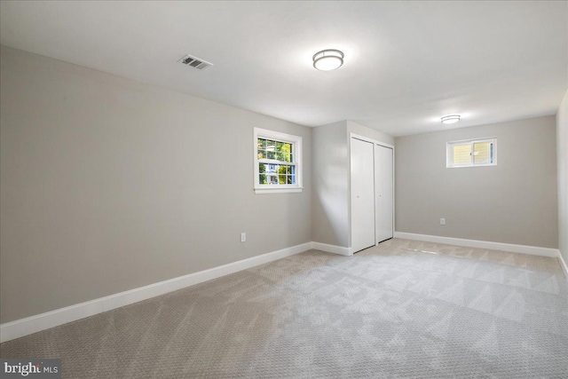 unfurnished bedroom with light carpet and a closet