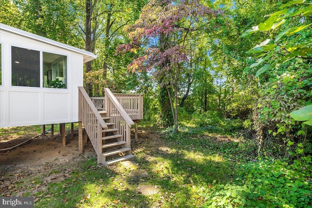 view of yard featuring a deck and a sunroom