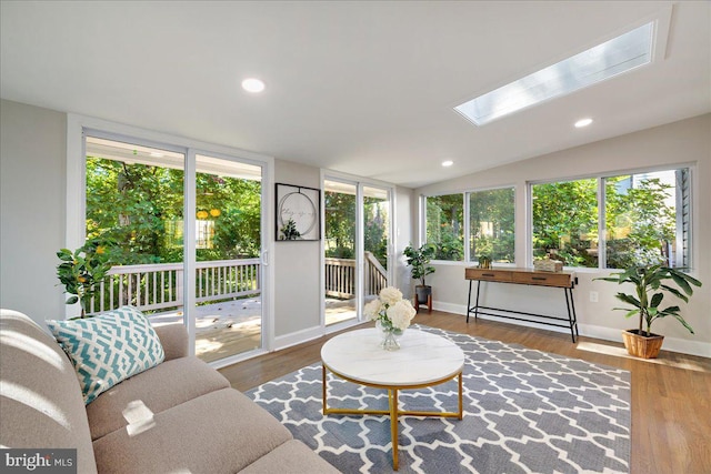 sunroom / solarium featuring lofted ceiling with skylight and a healthy amount of sunlight