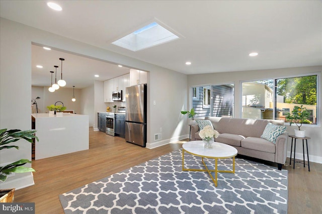 living room with light hardwood / wood-style floors and lofted ceiling with skylight