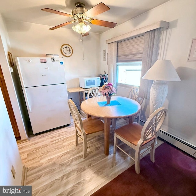 dining space with ceiling fan and light hardwood / wood-style floors