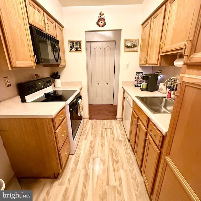 kitchen featuring white appliances, light hardwood / wood-style floors, and sink