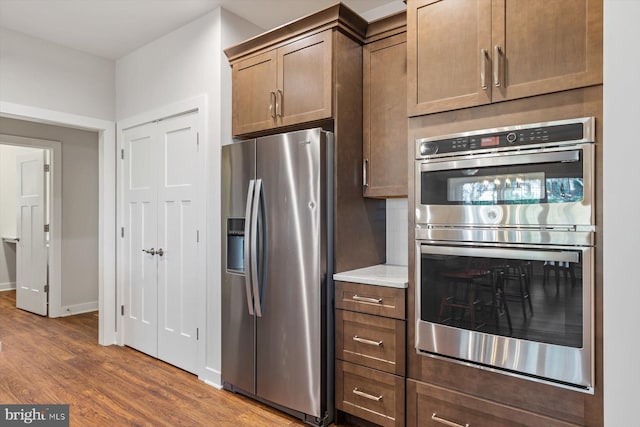 kitchen with dark hardwood / wood-style floors and appliances with stainless steel finishes