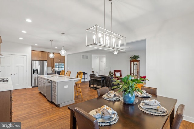 dining space with light wood-type flooring and sink