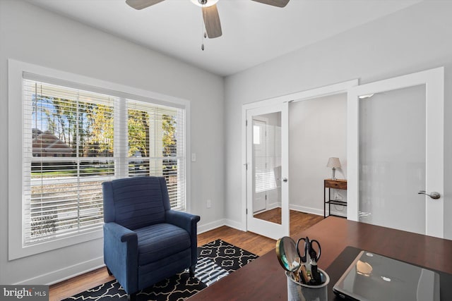 living area with ceiling fan, hardwood / wood-style floors, and french doors