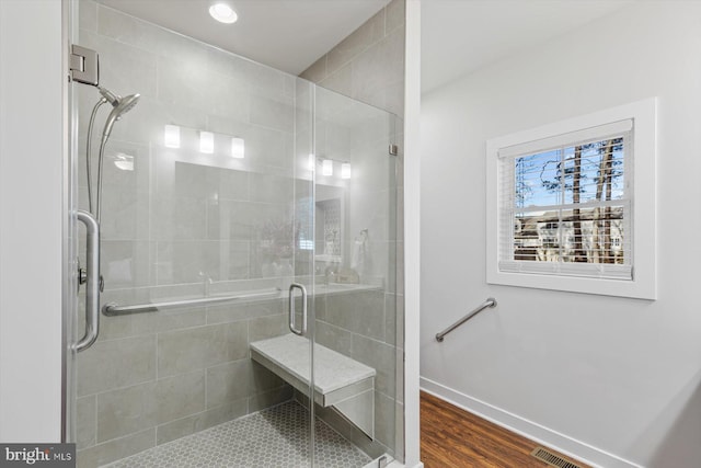 bathroom featuring hardwood / wood-style flooring and a shower with door