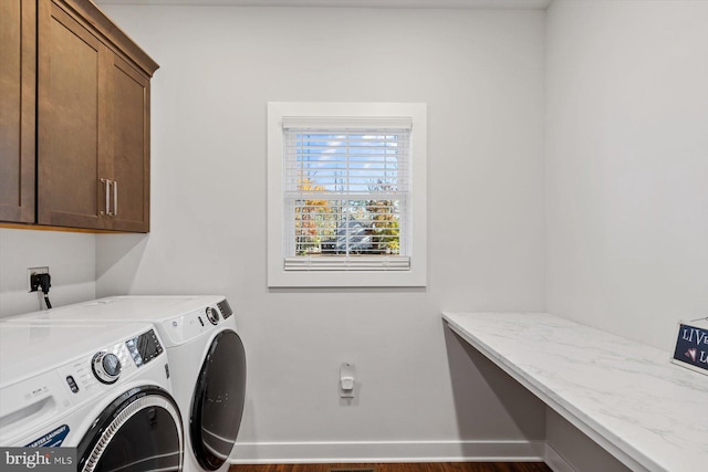 laundry room featuring cabinets, dark hardwood / wood-style flooring, and washer and clothes dryer