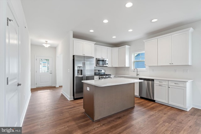 kitchen featuring white cabinets, a kitchen island, dark wood-type flooring, sink, and stainless steel appliances