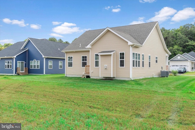 back of house featuring central AC, a garage, and a lawn