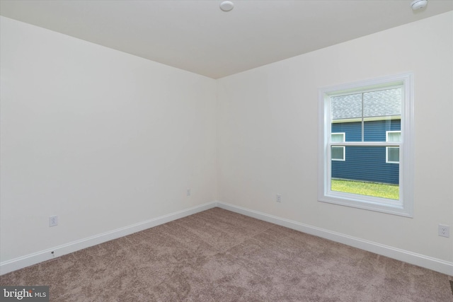 unfurnished room featuring light carpet