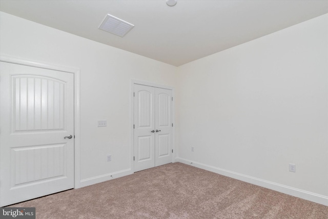 unfurnished bedroom with a closet and carpet floors