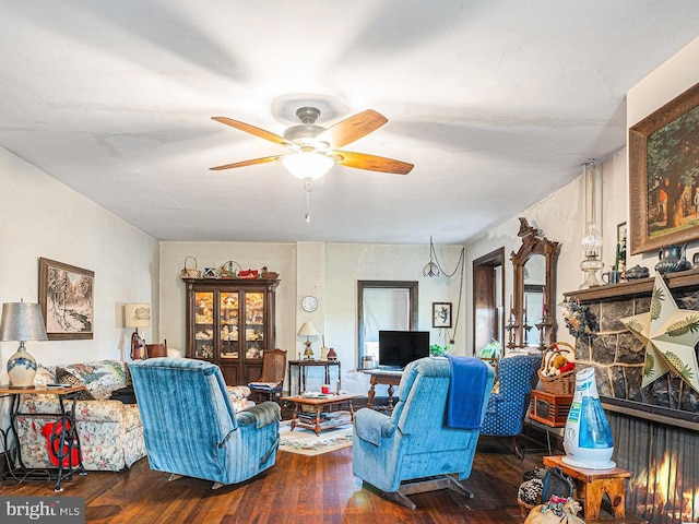 living room featuring ceiling fan and dark hardwood / wood-style floors