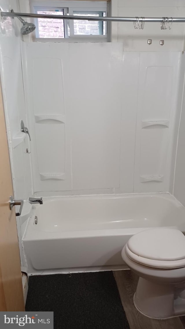 bathroom with toilet and bathing tub / shower combination