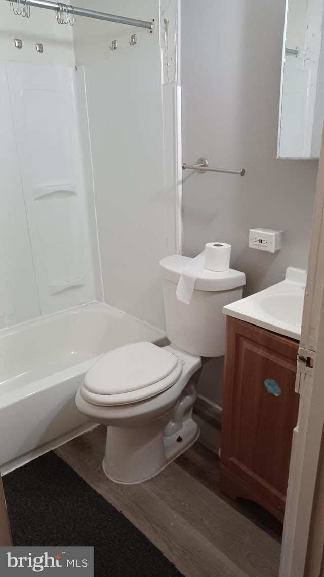 full bathroom with vanity, hardwood / wood-style floors, bathing tub / shower combination, and toilet