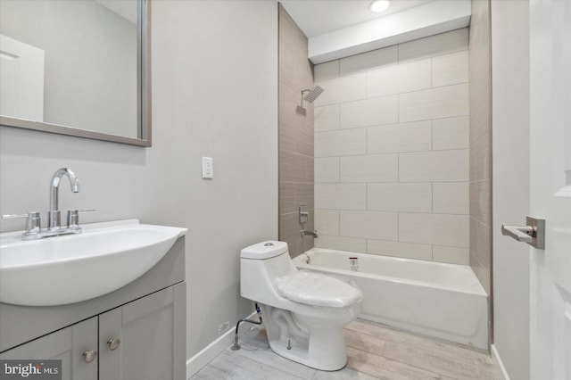 full bathroom with toilet, tiled shower / bath combo, vanity, and hardwood / wood-style floors