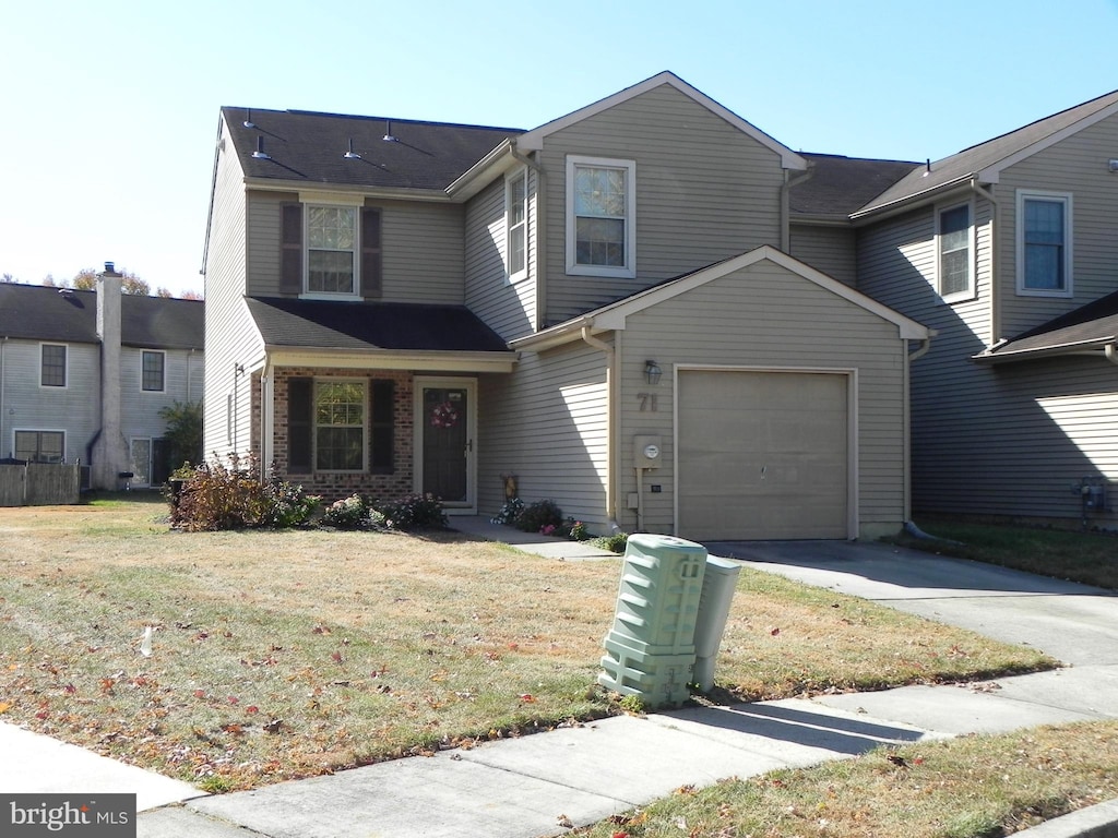 view of front of property featuring a front lawn and a garage