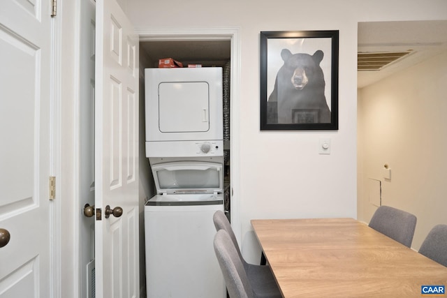 clothes washing area with stacked washer / dryer