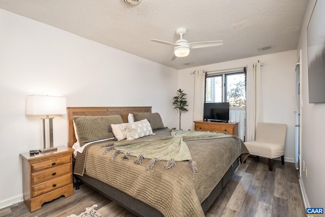 bedroom featuring hardwood / wood-style floors, a textured ceiling, and ceiling fan