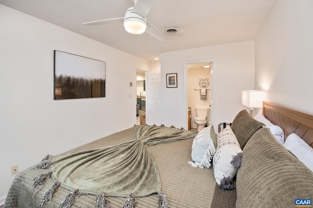 bedroom with ceiling fan, a textured ceiling, and ensuite bath