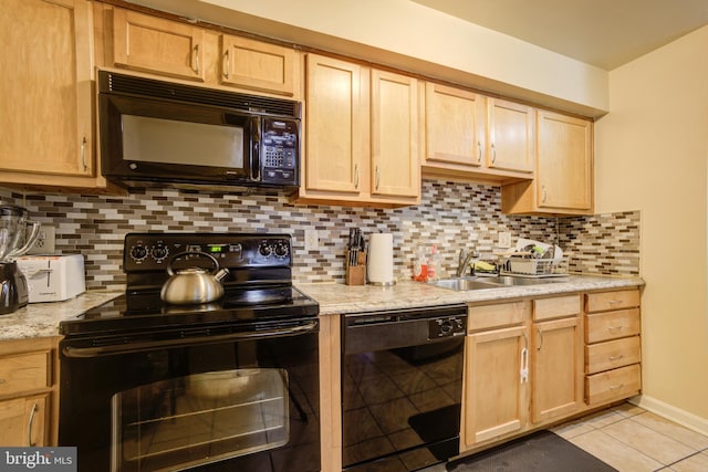 kitchen with light tile patterned floors, black appliances, sink, and backsplash