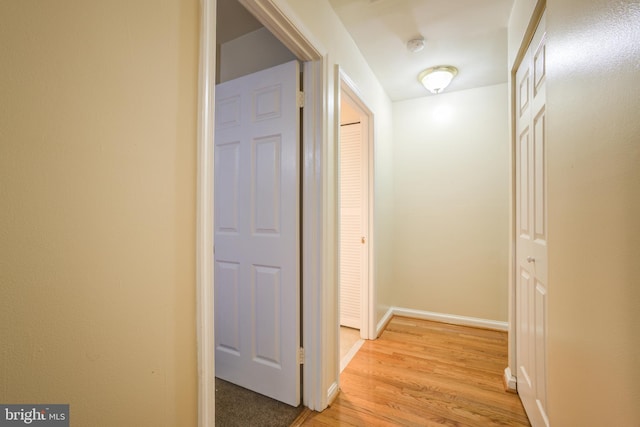 hallway with light hardwood / wood-style floors