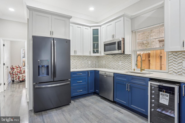 kitchen featuring white cabinets, stainless steel appliances, blue cabinets, and wine cooler