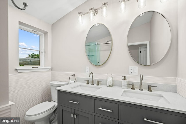 bathroom featuring toilet, vanity, and tile walls